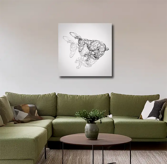 Fineart Print der Drahtfigur eines rennenden Hasen mit Schatten  vor hellem Hintergrund, an heller Wand mit grünem sofa